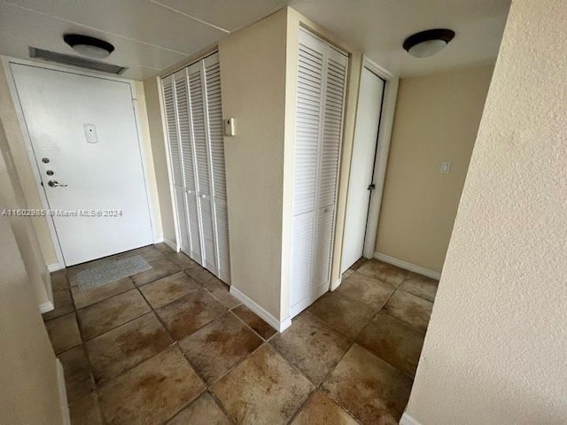 hall with dark tile patterned floors