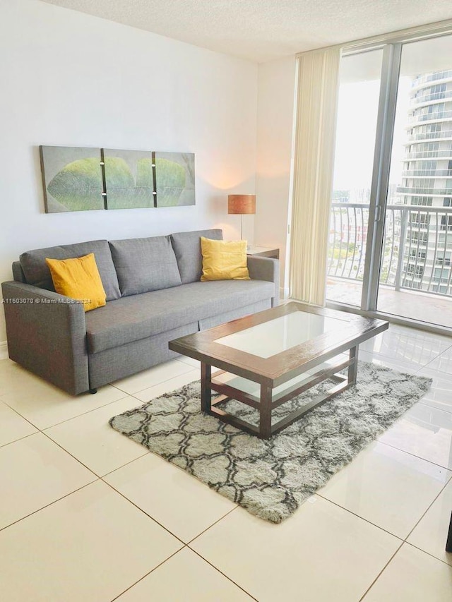 living area featuring tile patterned floors, floor to ceiling windows, and a textured ceiling