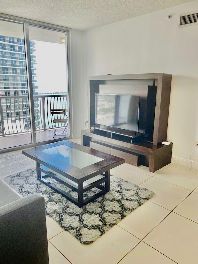 living room with floor to ceiling windows, tile floors, and a textured ceiling