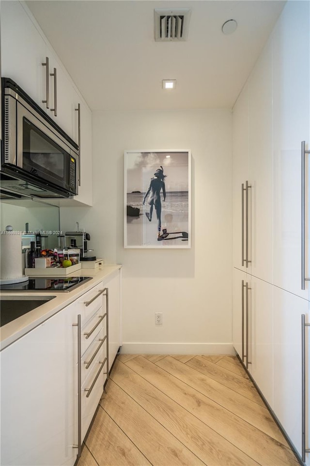 kitchen featuring white cabinetry and light wood-type flooring