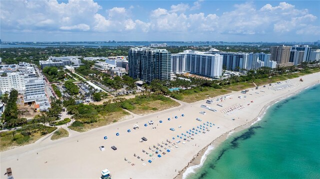 drone / aerial view featuring a beach view and a water view