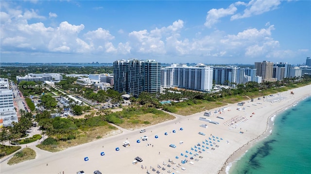 bird's eye view with a water view and a beach view