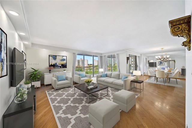 living room with light hardwood / wood-style flooring, a chandelier, and a wall of windows