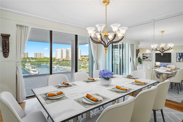 dining room with a water view, a chandelier, and light hardwood / wood-style floors