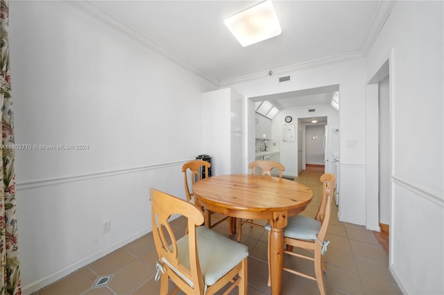 dining area featuring tile patterned flooring and ornamental molding