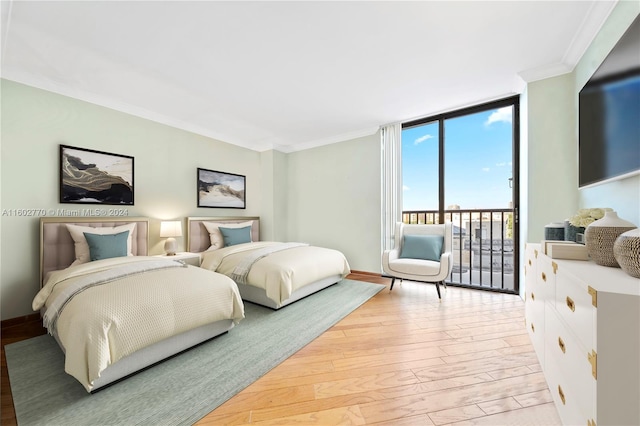 bedroom with access to exterior, light wood-type flooring, expansive windows, and ornamental molding