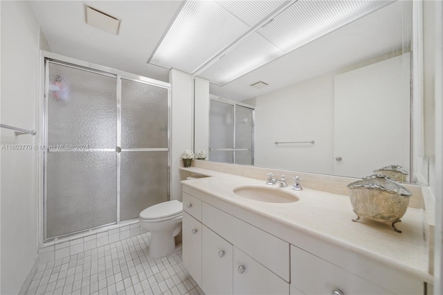 bathroom with tile patterned floors, vanity, toilet, and an enclosed shower