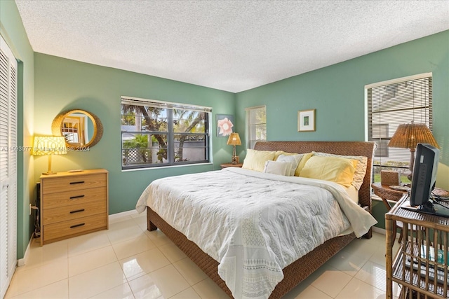 bedroom with a textured ceiling and light tile patterned floors