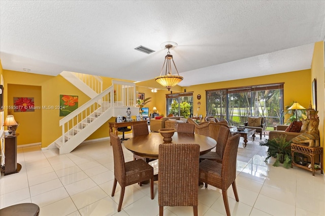 dining space with light tile patterned floors and a textured ceiling