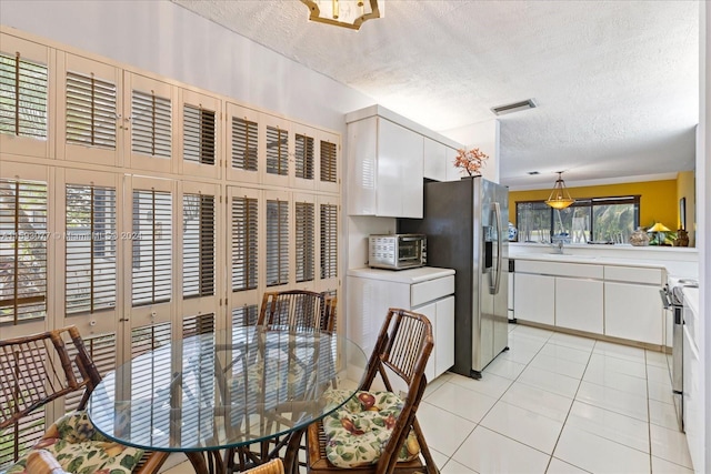 tiled dining area with a textured ceiling