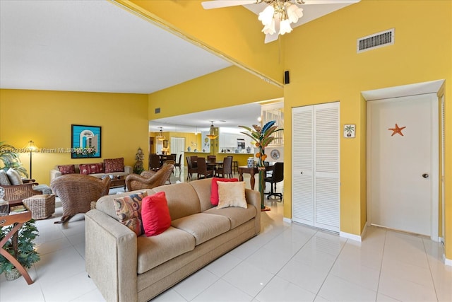 tiled living room with ceiling fan and lofted ceiling