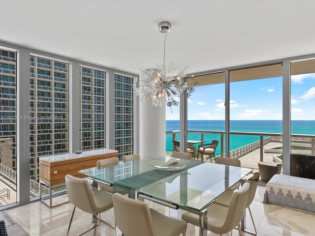 dining room featuring a chandelier, a water view, and floor to ceiling windows