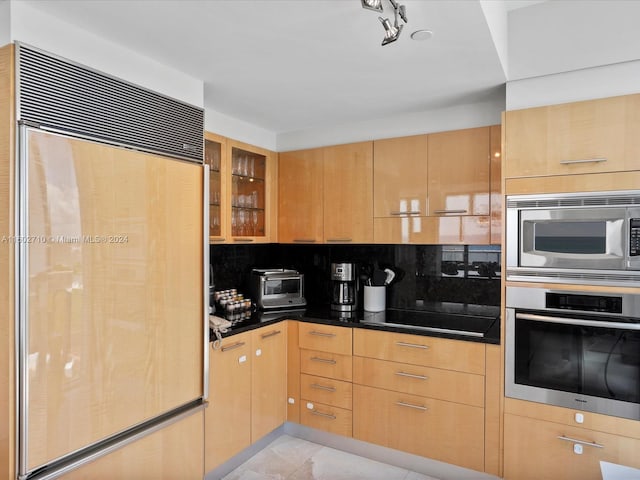 kitchen featuring built in appliances, decorative backsplash, light tile patterned flooring, and light brown cabinets