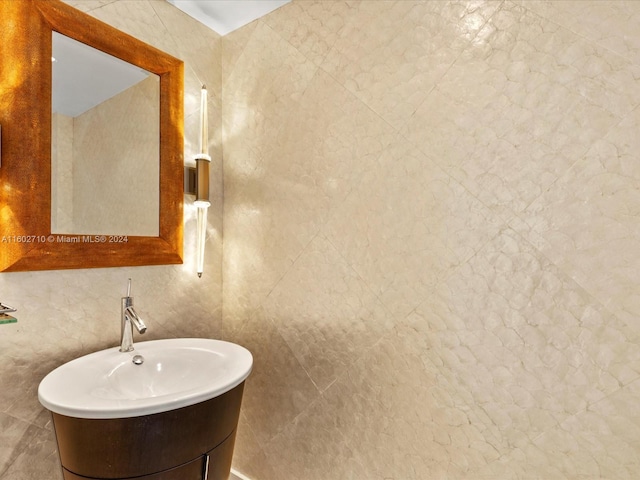 bathroom featuring vanity and tile walls