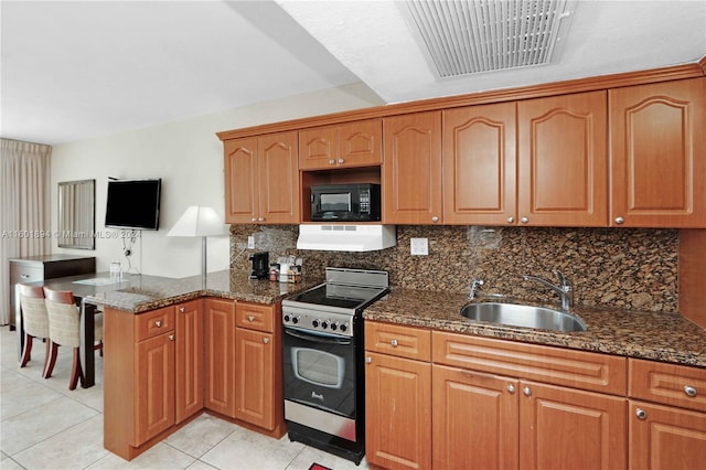 kitchen featuring dark stone counters, stainless steel gas range oven, sink, and exhaust hood