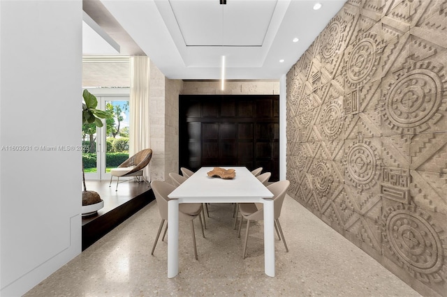 dining space with a raised ceiling