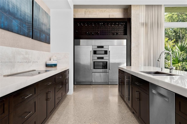 kitchen featuring appliances with stainless steel finishes, dark brown cabinets, and sink