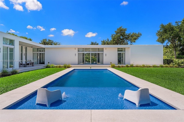 view of swimming pool with pool water feature, a patio, and a lawn