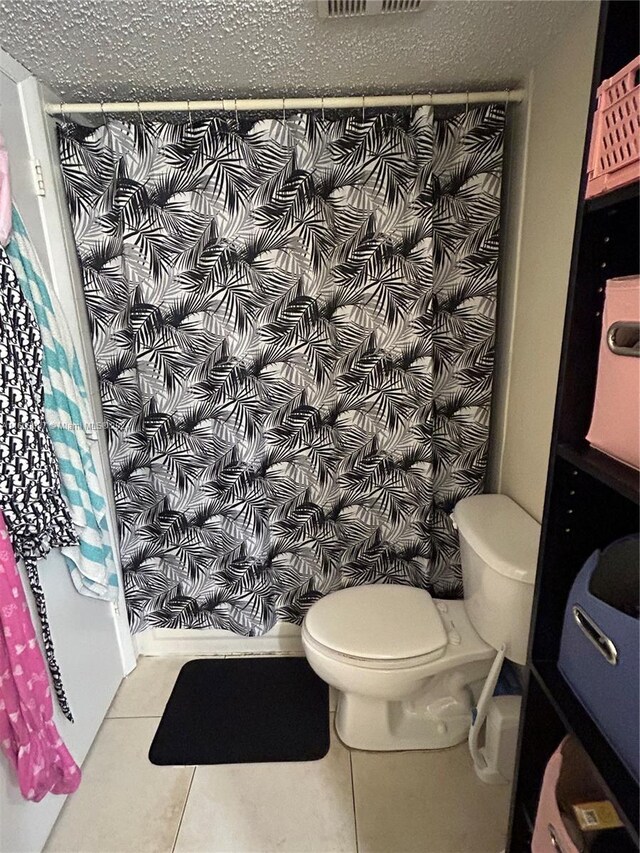 bathroom with toilet and tile patterned floors