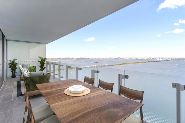 balcony with outdoor dining area and a water view