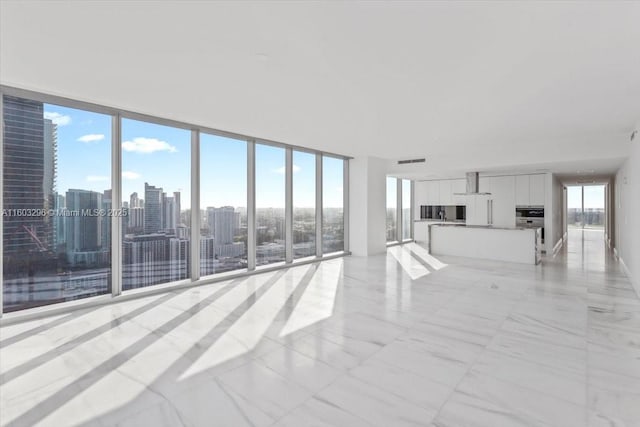 unfurnished living room with visible vents and a city view