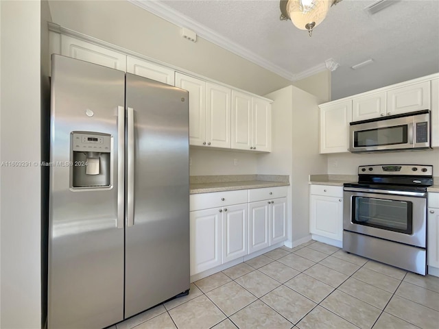 kitchen with crown molding, white cabinets, light tile floors, and stainless steel appliances