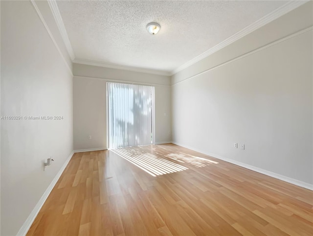 spare room with a textured ceiling, light wood-type flooring, and crown molding