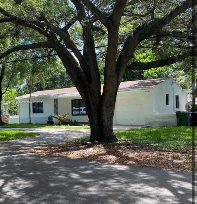 view of front of home featuring stucco siding, aphalt driveway, and brick siding