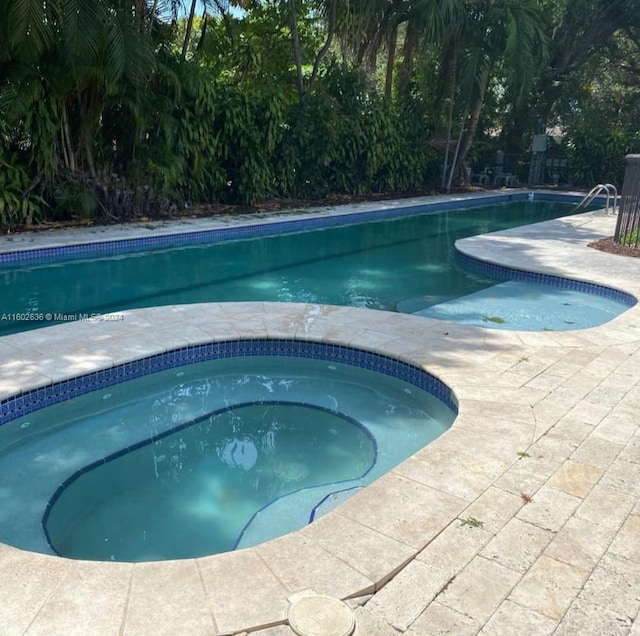 view of pool with an in ground hot tub