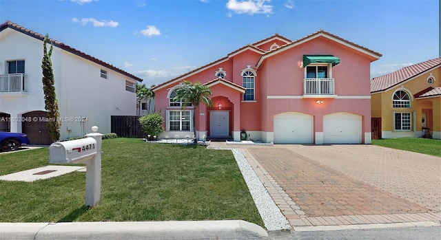 mediterranean / spanish-style home featuring a balcony, a garage, and a front yard