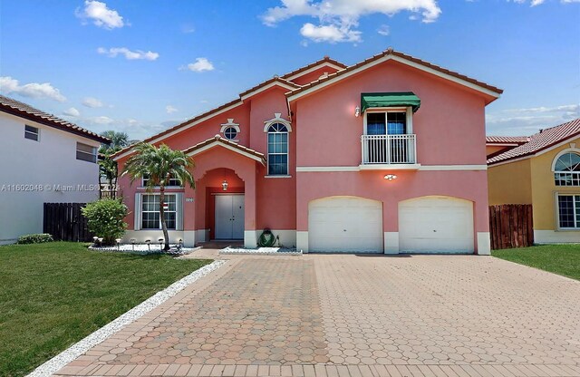 mediterranean / spanish-style house with a balcony, a garage, and a front lawn