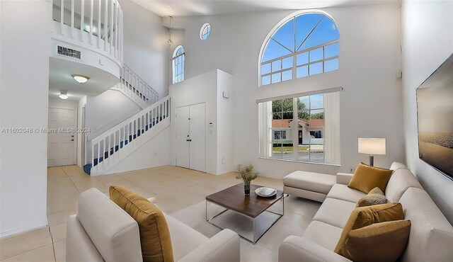 tiled living room featuring a towering ceiling