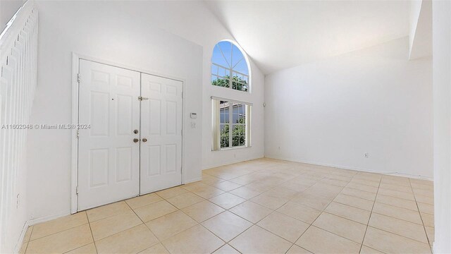 tiled entrance foyer featuring lofted ceiling