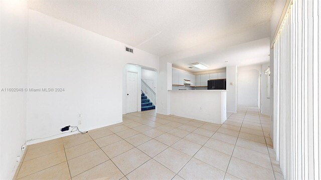 empty room featuring light tile patterned flooring and a textured ceiling