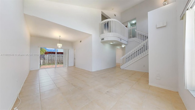 unfurnished living room with a high ceiling and light tile patterned floors