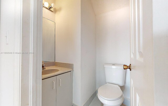 bathroom with vanity, tile patterned flooring, and toilet