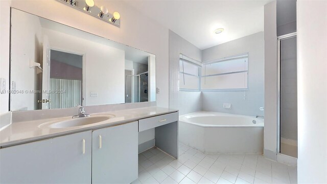 bathroom featuring vanity, tile patterned flooring, and separate shower and tub