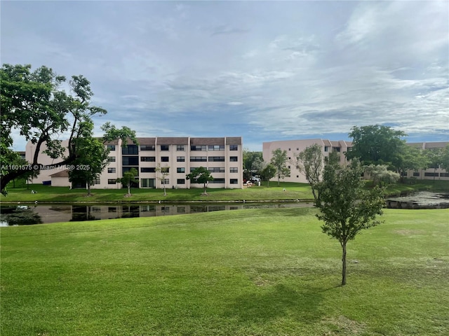 view of home's community featuring a water view and a lawn