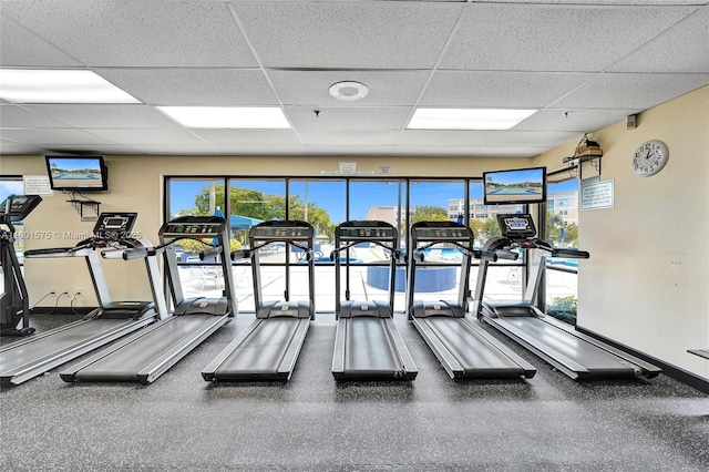 exercise room featuring a drop ceiling and a healthy amount of sunlight