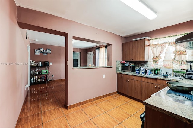 kitchen featuring backsplash, sink, and light tile floors