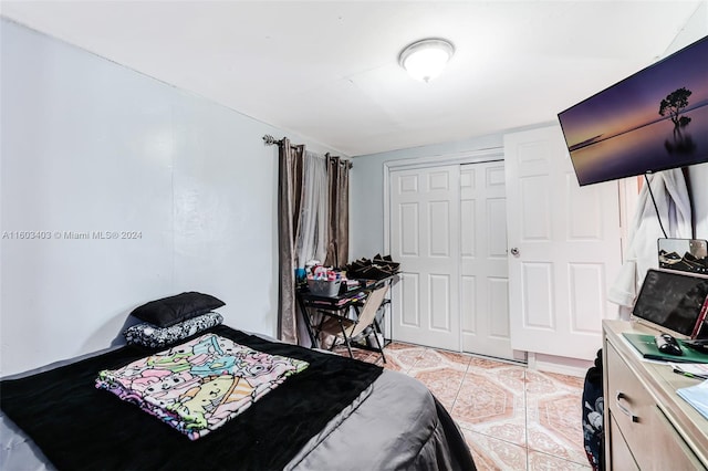 bedroom featuring a closet and light tile floors