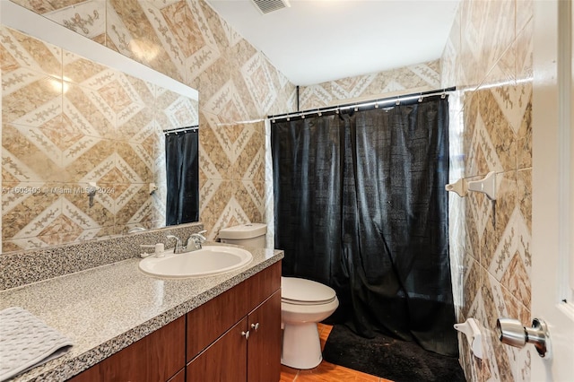 bathroom with tile walls, hardwood / wood-style flooring, toilet, and vanity