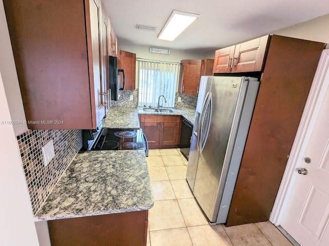 kitchen featuring sink, black appliances, tasteful backsplash, and light tile floors