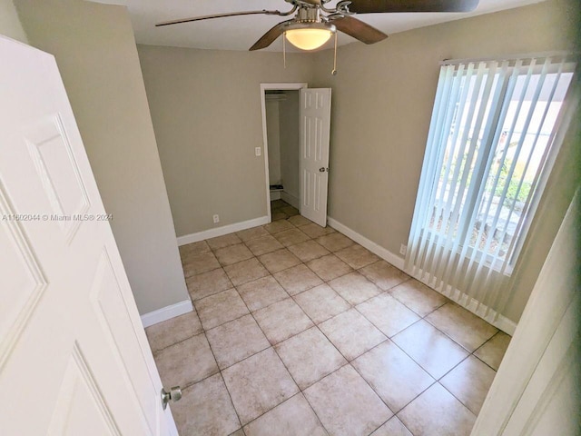 tiled empty room with ceiling fan