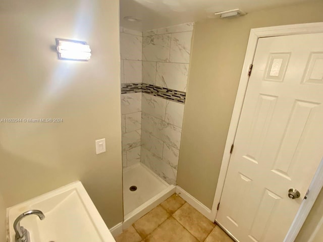 bathroom featuring tiled shower and tile flooring