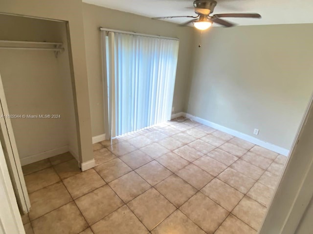 unfurnished bedroom featuring ceiling fan, a closet, and light tile floors