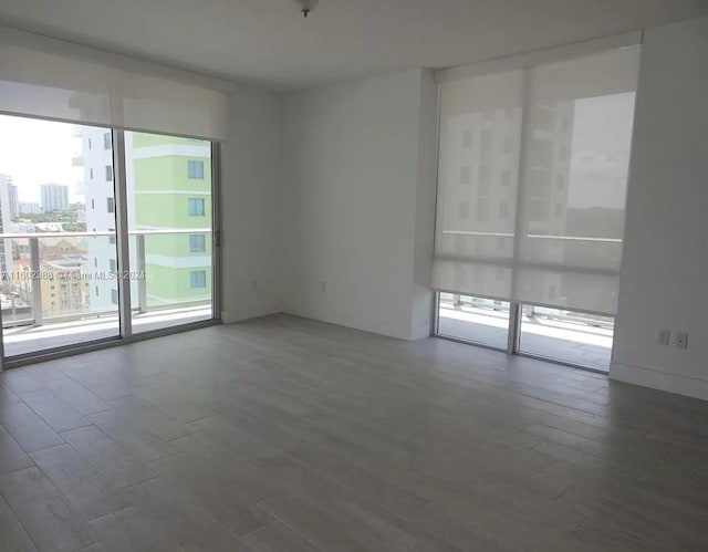 spare room with plenty of natural light and dark hardwood / wood-style floors