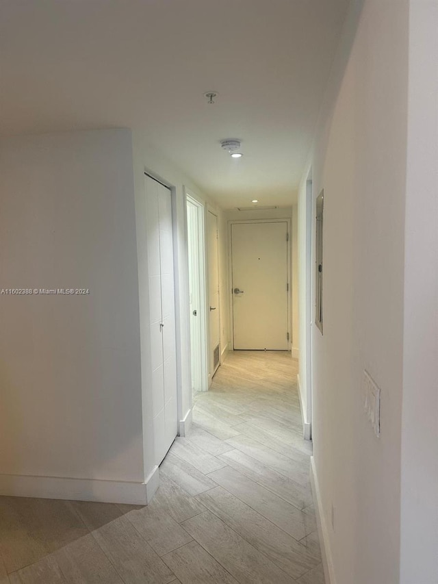 hallway with light hardwood / wood-style floors