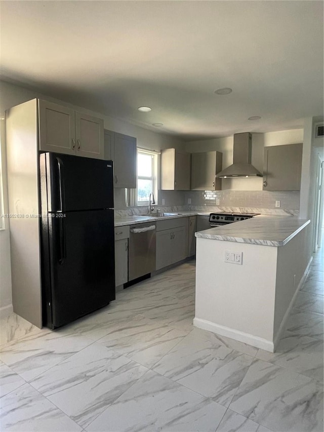 kitchen featuring backsplash, stainless steel appliances, wall chimney exhaust hood, and gray cabinetry