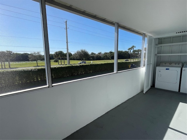 unfurnished sunroom featuring washing machine and clothes dryer